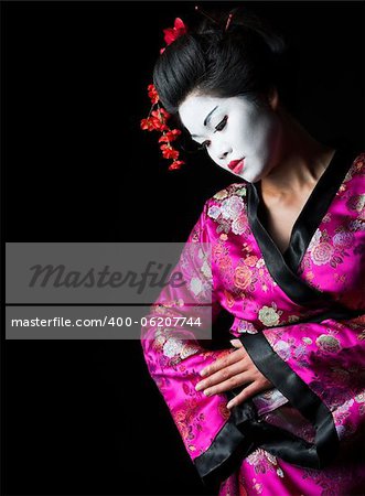 Closeup portrait of geisha isolated on black