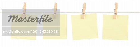 A set of four blank yellow sticky notes held on a string with clothespins isolated on white.