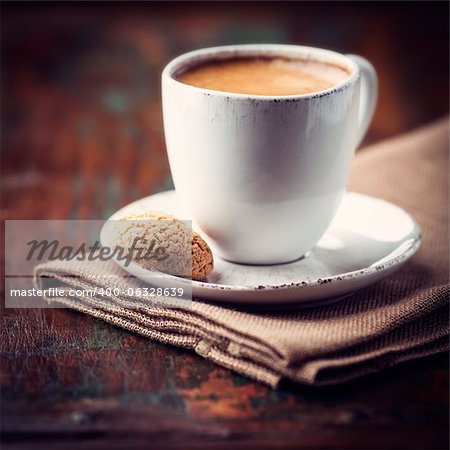 cup of espresso crema and biscotti ( focus on biscotti)