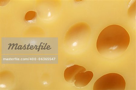Emmental cheese with many holes forming a background