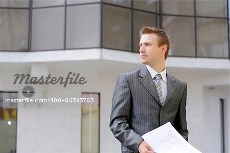 businessman holds contracts on the building background