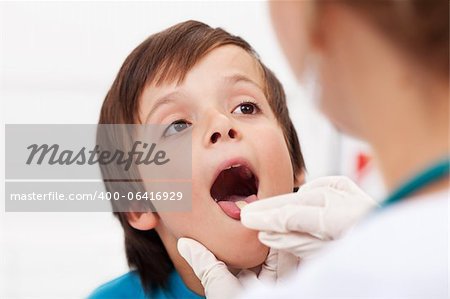 Say aaah - little boy having his throat examined by health professional - closeup