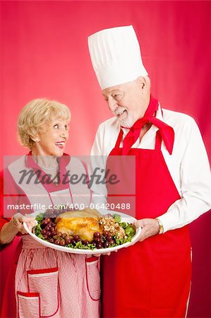Chef and homemaker collaborated on making a delicious holiday turkey dinner.  Red background.
