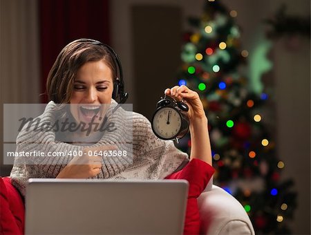 Happy young woman having video chat with family at New Year time