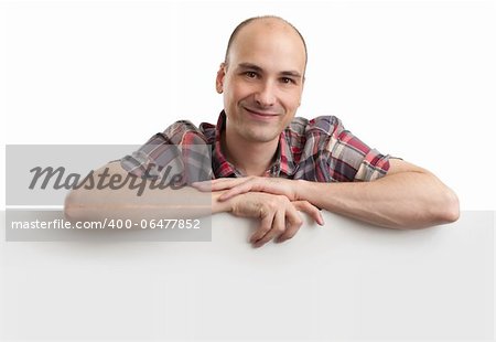 Happy young man showing placard ready for your text