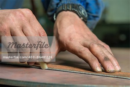A service repairmen labouring in manufacturing workshop during shift, selective focus