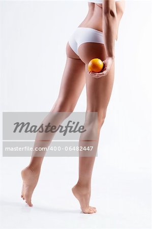Female hips with orange on white background