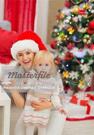 Portrait of smiling mother and baby with Christmas tree cookies