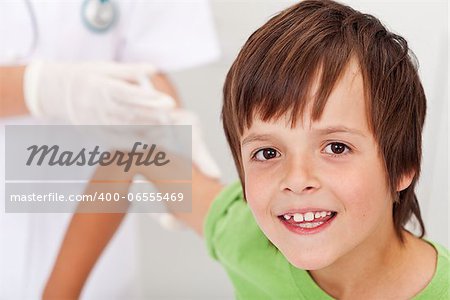 Happy boy receiving vaccine or injection - health professional in the background