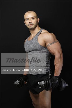 Fit Muscular Brazilian man with a set of dumbbells