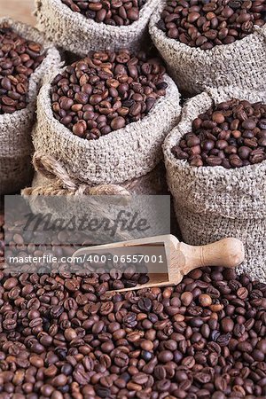 Coffee in burlap bags and spilled on the table - closeup