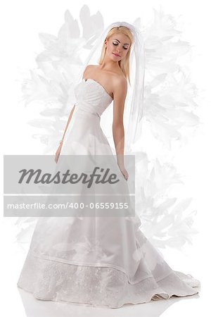 pretty girl with white wedding dress and veil, she looks down at left and touches the dress