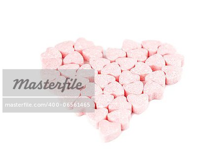 Heart made of little pink candy hearts isolated on white background