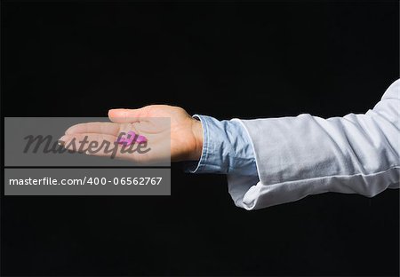 Closeup on hand with tablets isolated on black