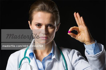 Medical doctor woman showing tablets isolated on black