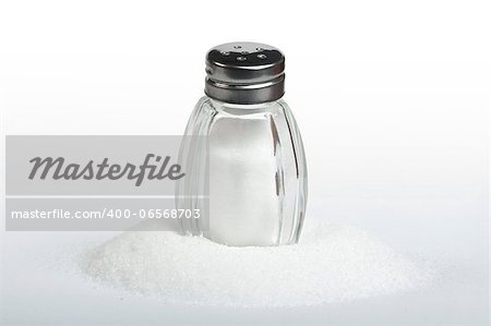 Salt and saltshaker on white background .