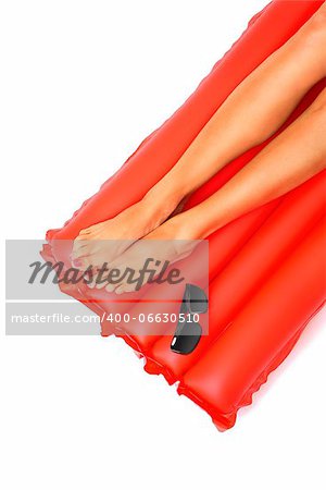A picture of female legs lying on a red inflatable mattress over white background
