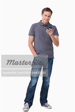 Young man holding his cellphone against a white background