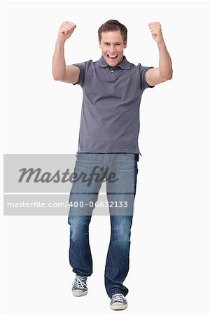 Cheering young man against a white background