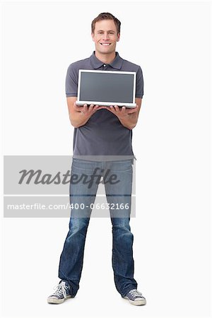Smiling young man showing his laptop screen against a white background