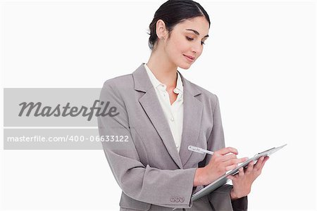 Businesswoman taking notes against a white background