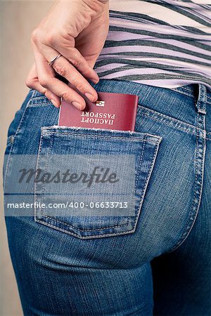 Shot of young womans behind in worn out jeans and passport in a pocket