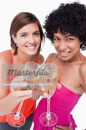Young females smiling and clinking glasses of white wine