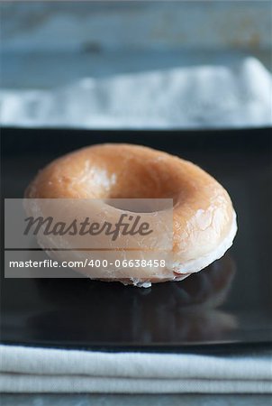 Fresh glazed doughnut on square black plate