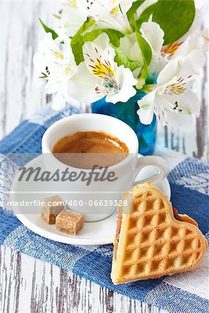 Sweet heart waffle and cup of coffee with brown sugar.