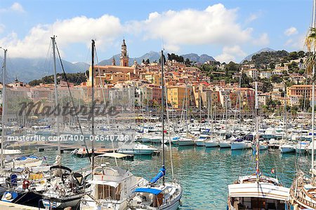 Yachts on marina and old town of Menton - popular resort on French Riviera.