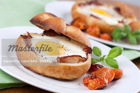 Eggs and bacon baked in buns with cherry tomatoes