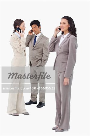 Businesspeople on their cellphones against a white background