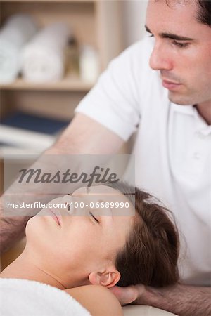 Serious doctor manipulating his patient in a room