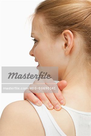 Young woman massaging her nape against white background