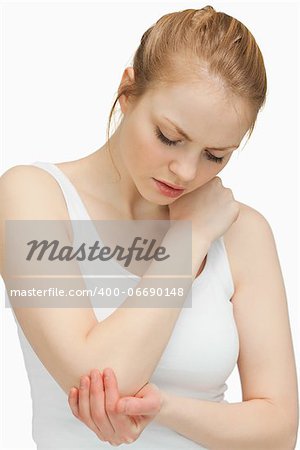 Woman touching her painful elbow against white background