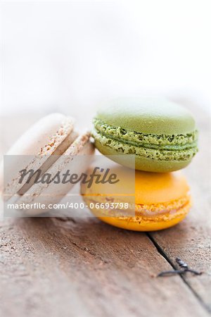 Closeup of three macaroons on wooden table surface