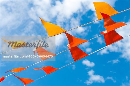 red and orange bunting flags against a blue sky