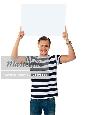 Confident young man showing blank billborad over his head