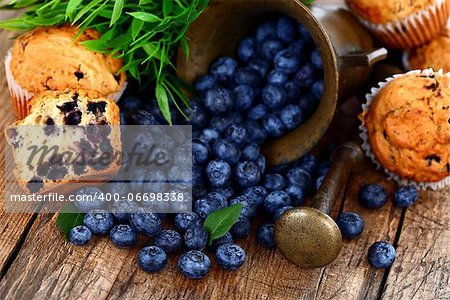 Muffins and blueberries on rustic wooden table