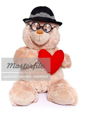 Teddy bear wearing glasses and hat holding red heart