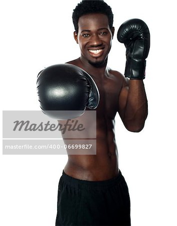 Shirtless african boxer throwing a punch at the camera