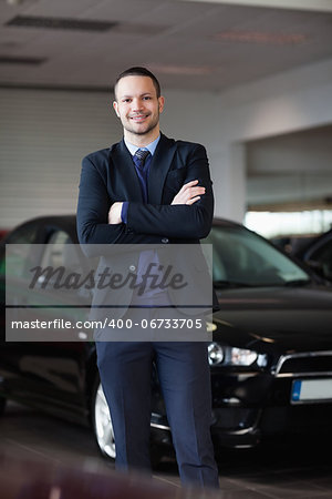 Salesman standing in front of car in a dealership