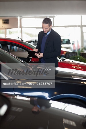 Man writing on a notepad in a garage