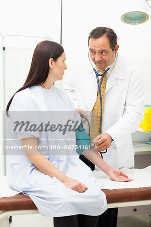 Doctor measuring the pressure of the blood of his patient in an examination room