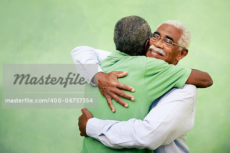 Active retired old men and leisure, two senior black brothers hugging outdoors