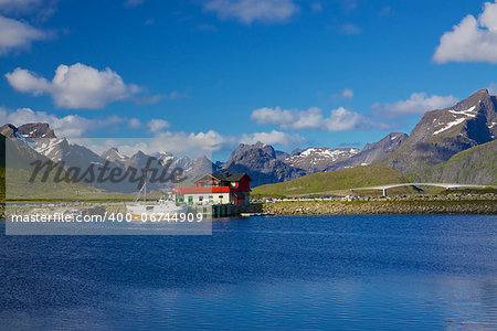 Scenic panorama on Lofoten islands in Norway with traditional norwegian fishing boat and high mountain peaks