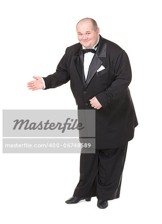 Elegant fat man in a dinner jacket and bow tie smiling charmingly as he holds out his hand to the side gesturing in that direction