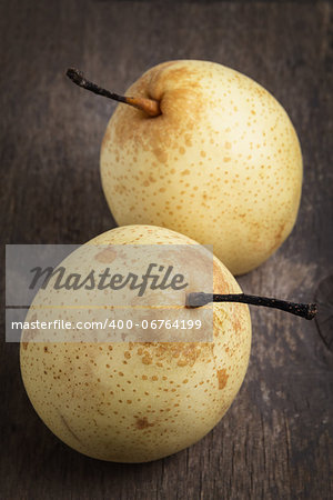 two asian ripe yellow pears on old wooden table, selective focus