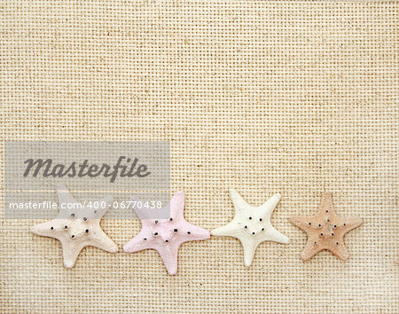 Background with starfishes on canvas texture