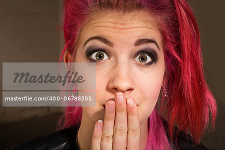 Young punk rocker in pink hair with hand on mouth